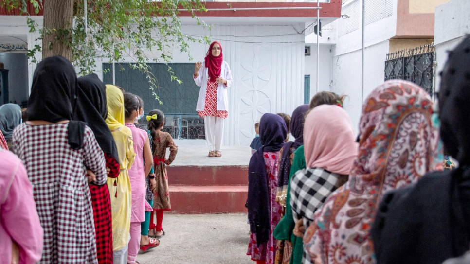 Frente a una asamblea en su antigua escuela, Saleema exhorta a las niñas refugiadas a seguir estudiando y no renunciar a sus sueños.