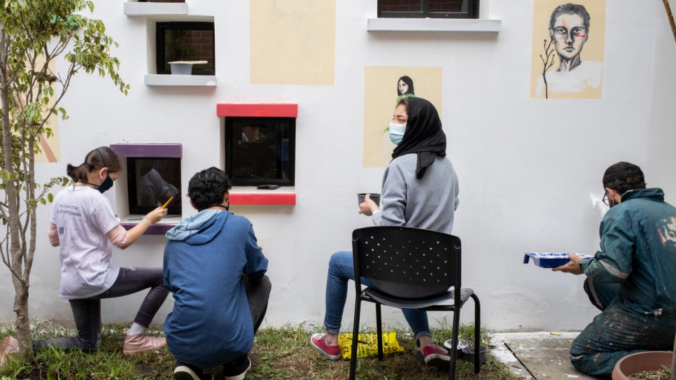 Zohra y otros artistas trabajando en pinturas murales en el Centro de Equidad y Justicia Calderón, en Quito.