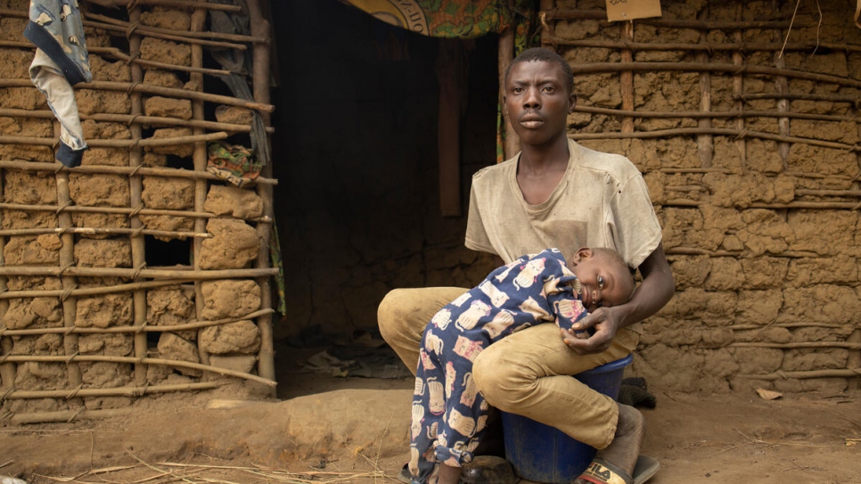 Mawaki Ngandibi, de 24 años, sentado con su hijo Doudé, de 18 meses, frente a su casa en Ngoulayo, República del Congo. 