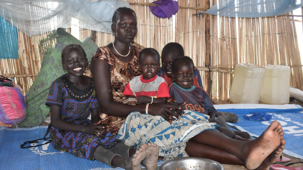 Una familia sudanesa refugiada sentada en un albergue comunitario después de haber sido reubicada en el campamento de Alganaa.