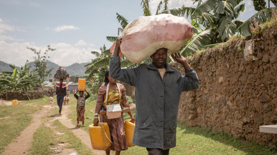 Twaza Enoch dirige a su familia mientras caminan hacia su casa en la República Democrática del Congo.