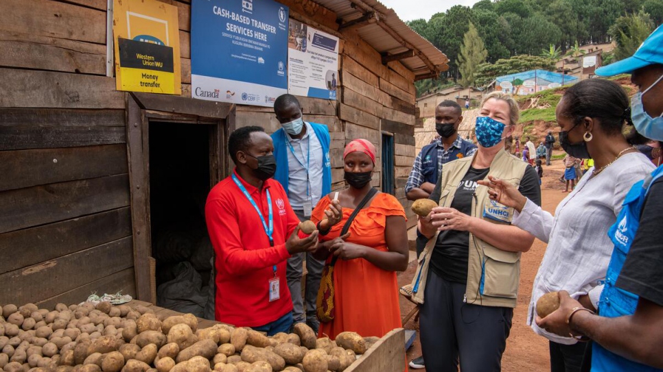 Kelly Clements (centro), Alta Comisionada Adjunta para los Refugiados, conversa con Olive Kanyange, comerciante y refugiada congolesa, en el campamento de refugiados de Mugombwa, Ruanda.