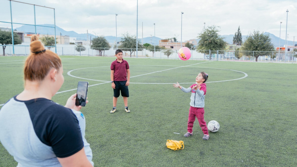 Como parte de la clase en línea de educación física, Dania graba a su hija y a su hijo mientras juegan.