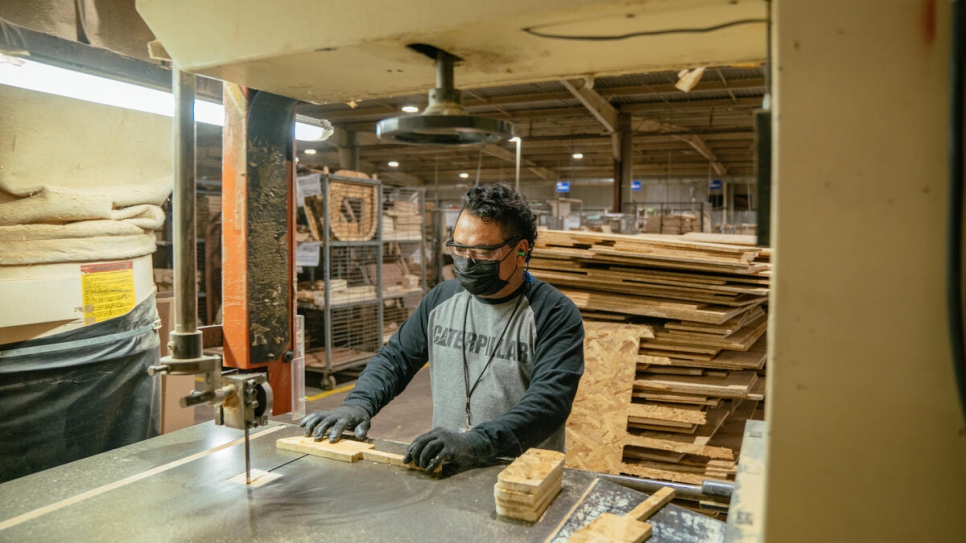 César encontró trabajo en una fábrica de muebles, donde corta madera que se convertirá en sofás y sillas.