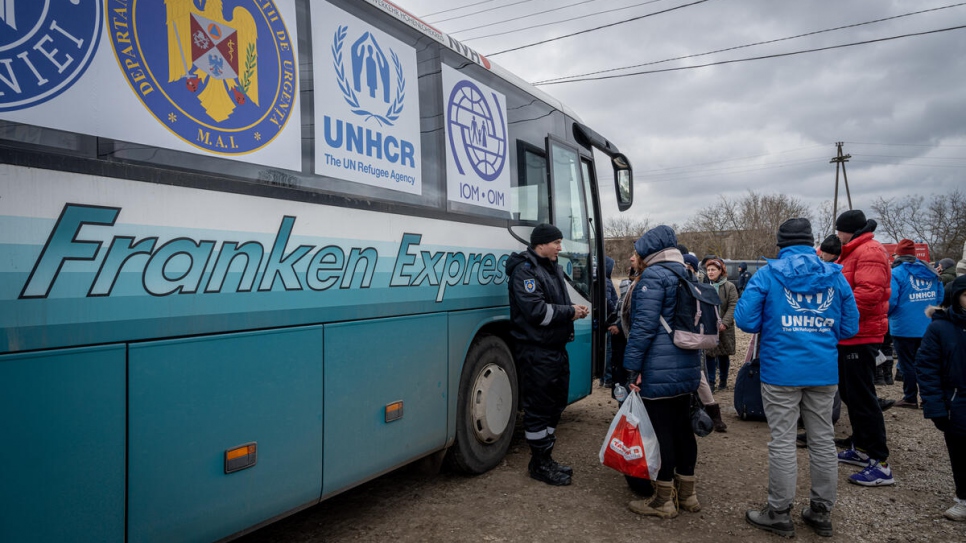 Las personas refugiadas suben a los autobuses en el cruce fronterizo de Palanca, Moldavia, para llegar a Rumanía.
