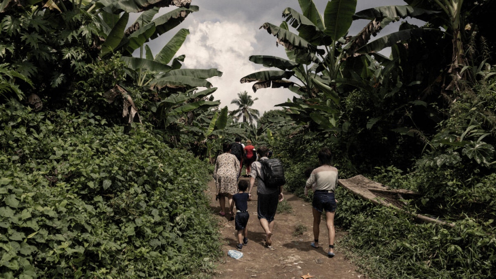 Un grupo de personas refugiadas y migrantes camina hacia el pueblo de Canaan, en el extremo sur de Panamá, tras cruzar el Tapón del Darién.