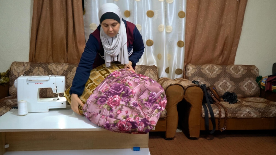 Zuzan Mustafa, mujer de 36 años originaria de Alepo, Siria, huyó a Jordania junto con su esposo y tres hijos. Las personas sirias refugiadas enfrentan dificultades para encontrar trabajo en Jordania. Zuzan pudo echar mano de sus habilidades con el hilo y la aguja para generar ingresos.