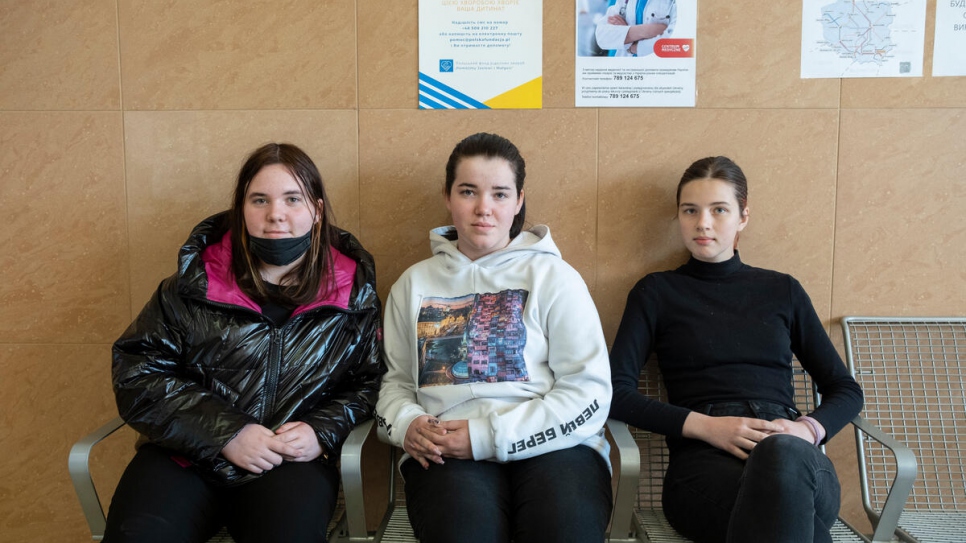 Angelina (centro), de 18 años, junto a su hermana, Albina (14 años), y su prima, Victoria (18 años), en una sala de espera en la estación de trenes de Rzeszów. Cuando llegó a Polonia de Ucrania, Angelina aceptó que un extraño la llevara en su vehículo a su destino.