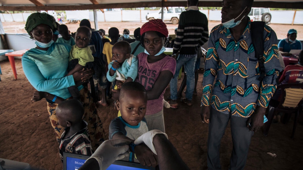 Una familia de personas refugiadas centroafricanas espera para completar los procedimientos de salida antes de abordar en un vuelo de regreso a casa.