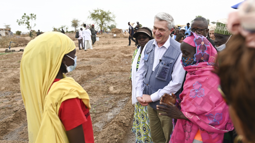 Filippo Grandi (centro-derecha) y Millicent Mutuli, Directora de la Oficina Regional de ACNUR para África Occidental y Central (centro-izquierda), se reúnen con uno de los residentes del asentamiento de Ardjaniré.