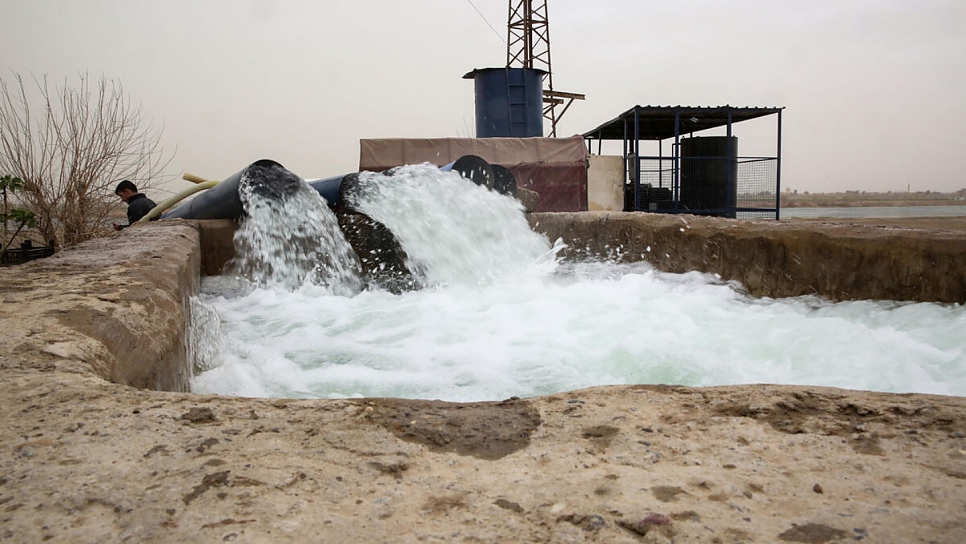 El agua fluye por los canales de concreto tras las reparaciones de una estación de riego cerca de Deir ez-zor.