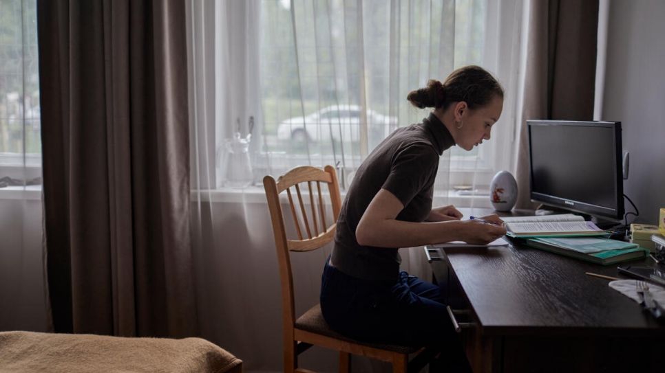 Daria estudia en un escritorio en el dormitorio de la familia donde se une a las clases en línea con sus profesores y compañeros de Ucrania.