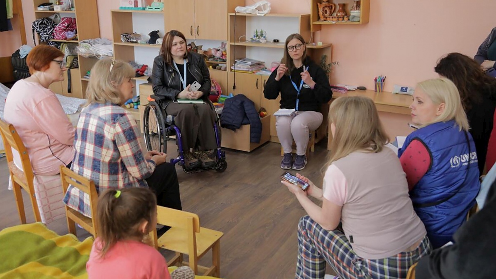 Tetiana y personal de ACNUR se reúnen con personas desplazadas, algunas de ellas con problemas de movilidad, en un centro de rehabilitación para personas con discapacidad en la ciudad de Svaliava, en la provincia de Zakarpattia.