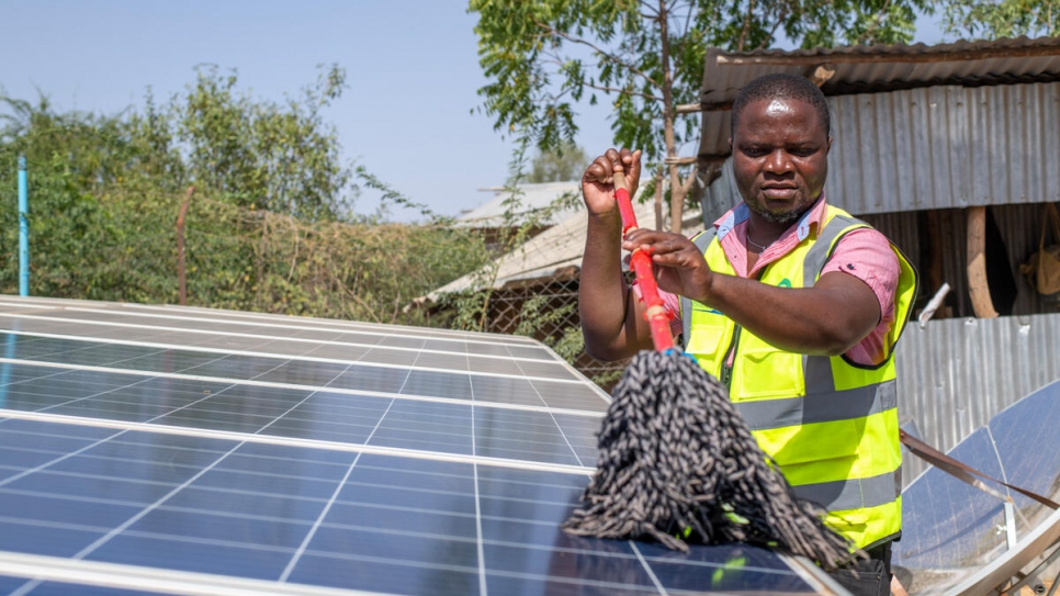 Vasco limpia los paneles solares de su pequeña planta para la producción de energía eléctrica, en el campamento de refugiados de Kakuma.