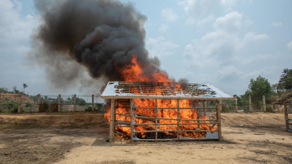 Como parte de un simulacro para que las personas refugiadas aprendan a controlar los incendios, se quema un alojamiento construido para tal fin.
