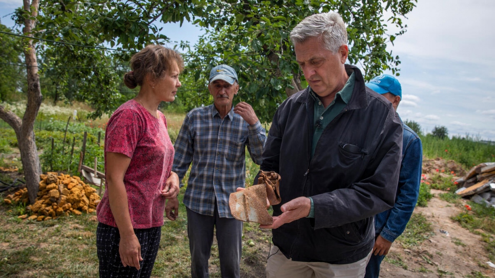 Filippo Grandi, Alto Comisionado para los Refugiados, sostiene un trozo del misil que destruyó la casa de esta familia.