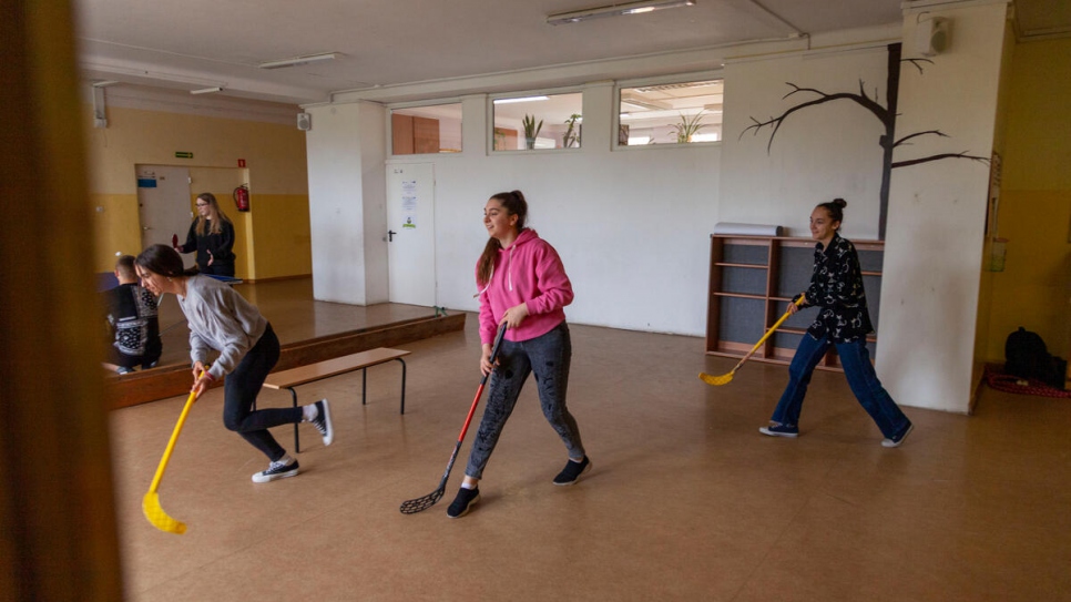 Sofía juega hockey con sus compañeros durante una clase de educación física.