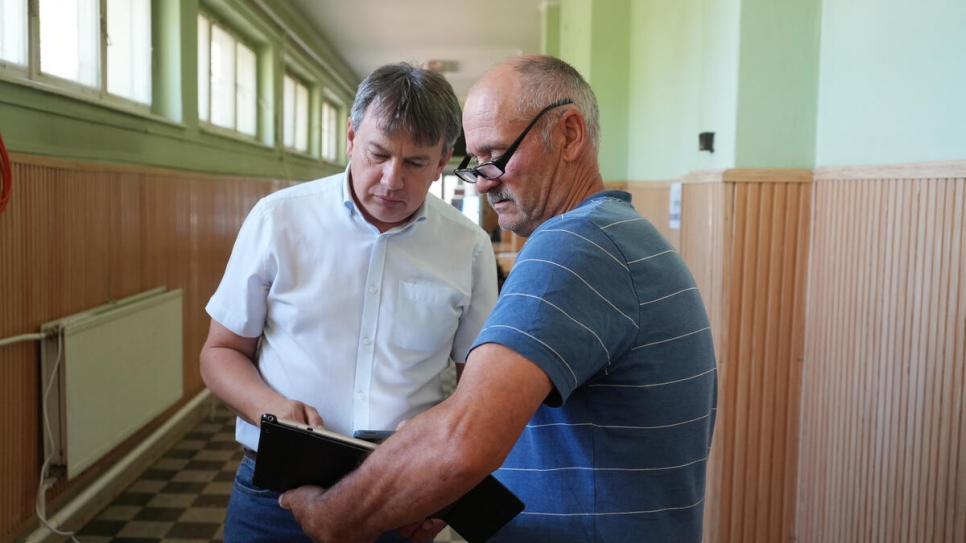 László Helmeczi habla de las opciones de alojamiento con el refugiado ucraniano Géza Vinda en el albergue de emergencia de Záhony.