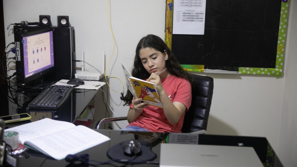 María, una niña venezolana que participa en el programa "Chamas en Acción", estudiando en su casa en Lima, Perú.