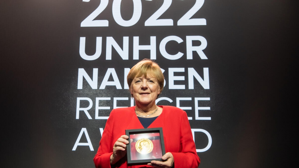 La Dra. Merkel sostiene el premio global durante la ceremonia de entrega del Premio Nansen para los Refugiados de ACNUR 2022.