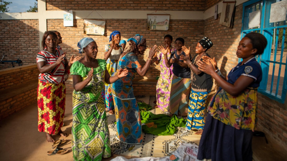Ngena (al centro, con vestido azul) y sus compañeras cantan juntas durante un descanso de su trabajo.
