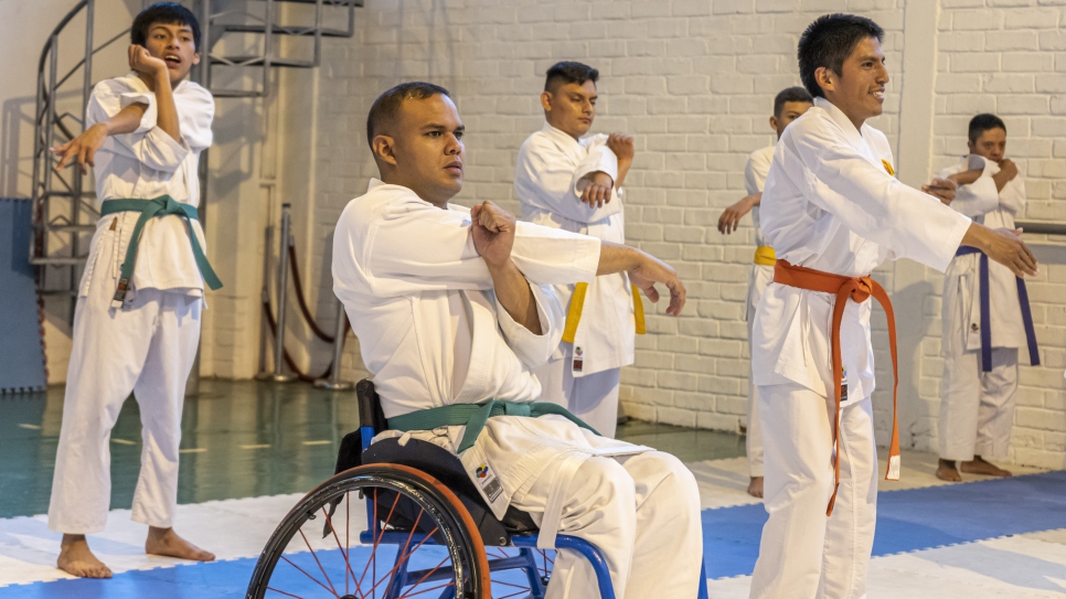 Carlos Acosta, refugiado venezolano, se prepara con su equipo para comenzar el entrenamiento de para-karate en Quito.