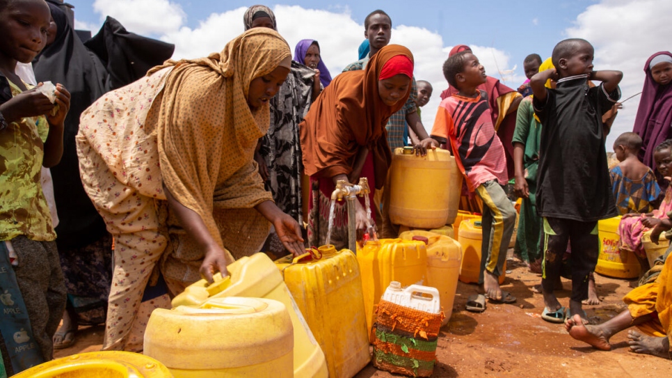 Personas refugiadas recién llegadas de Somalia esperan turno para recoger agua de un depósito en el campamento de Dagahaley, en Dadaab, Kenia.