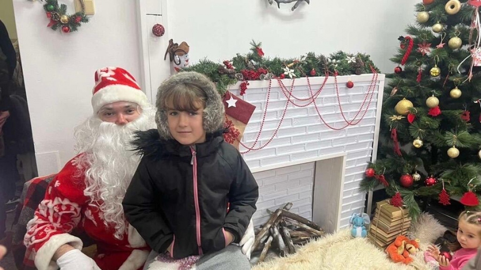 La refugiada ucraniana Sofía conoce a Santa Claus durante un bazar de beneficencia navideño en el hospital.