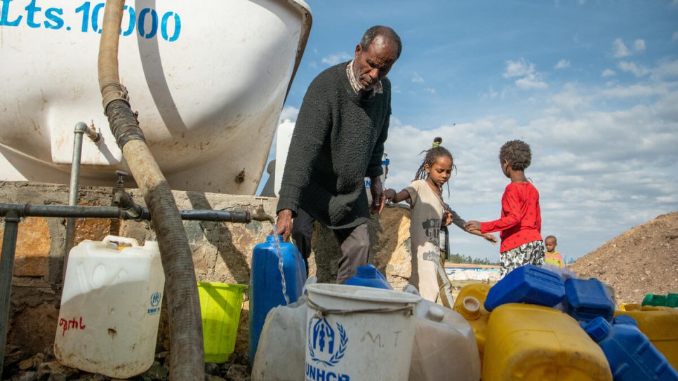 Un refugiado eritreo recoge agua para su familia en Alemwach.