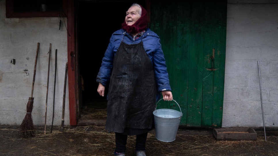 Kateryna recoge leche de la vaca de la familia, a la que se resistía a abandonar durante lo peor de los combates.