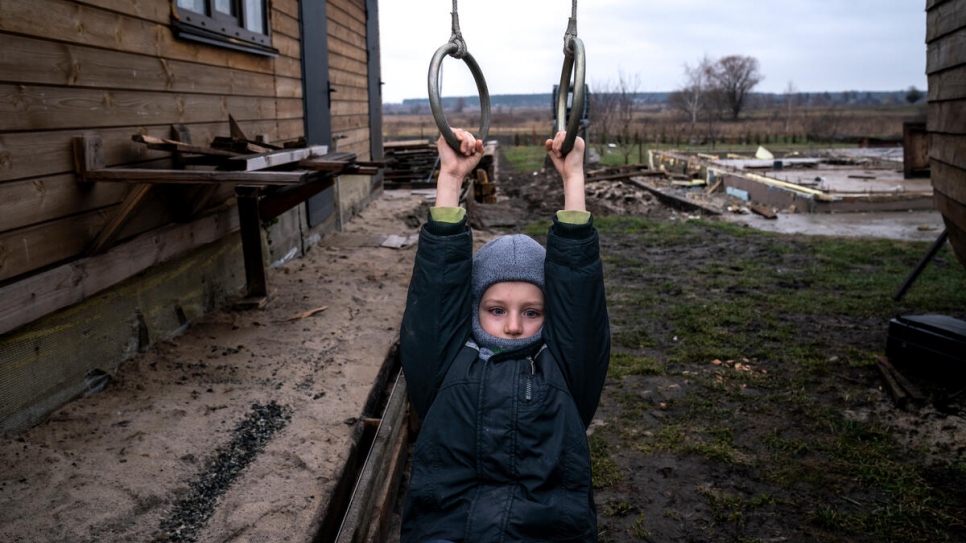 Ivan juega en un columpio que su padre construyó para él en el patio de lo que solía ser su casa.