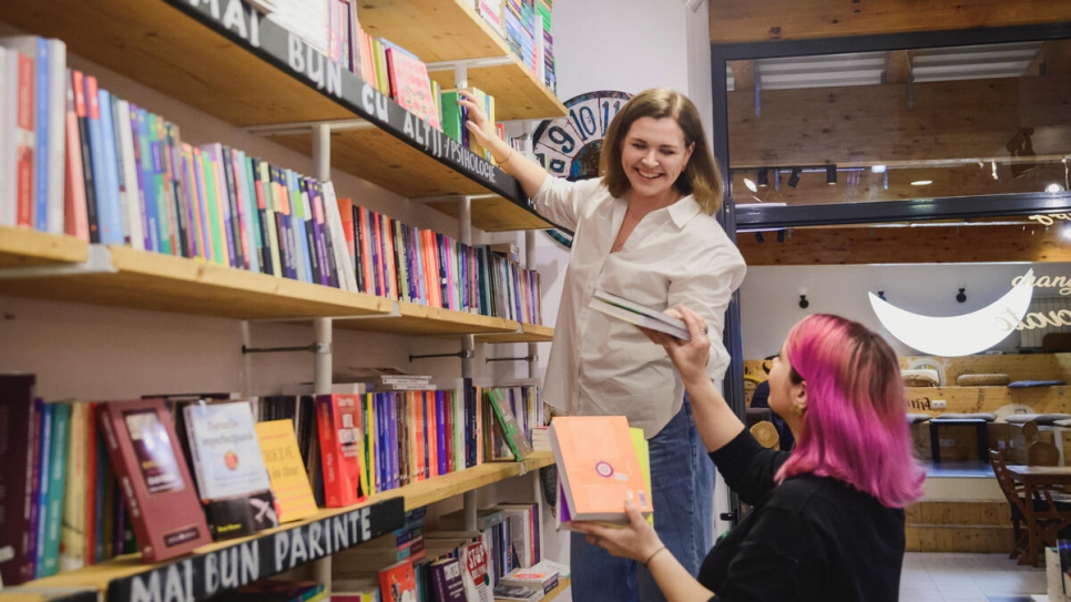 Ekaterina y Stefania apilan libros en Seneca Anticafé, una librería y espacio de trabajo compartido en la que ambas trabajan.