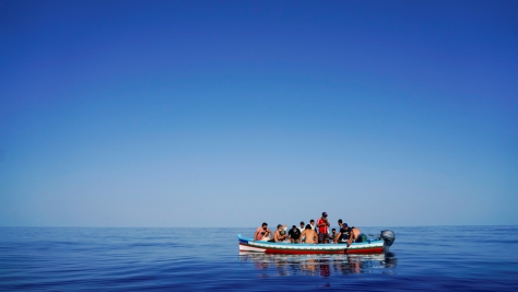 A la deriva, en una embarcación de madera, personas refugiadas y migrantes esperan ser rescatadas cerca de Lampedusa, una isla italiana en el mar Mediterráneo (28 de agosto de 2021).