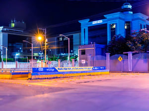 Un edificio iluminado de azul. En una barda de lee "nadie elige huir, pero todos podemos elegir apoyar"