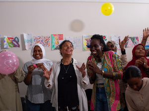 Mujeres aplauden, sonríen y lanzan globos al aire