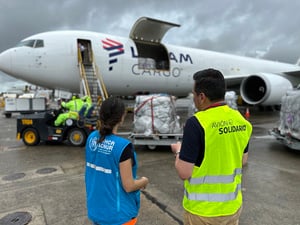 Funcionarios de ACNUR y de LATAM reciben un cargamento de artículos ayuda en el aeropuerto de Tocumen, en Panamá.