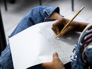 Primera plana de una mano escribiendo una carta.