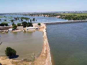 Las inundaciones rodean edificios, árboles y un largo puente