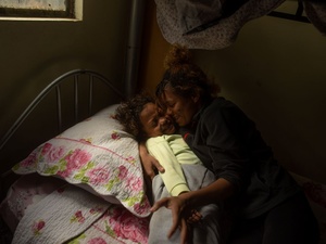 Una mujer abraza a un niño antes de dormir.