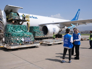 Personal de ACNUR posa junto a un avión que transporta suministros